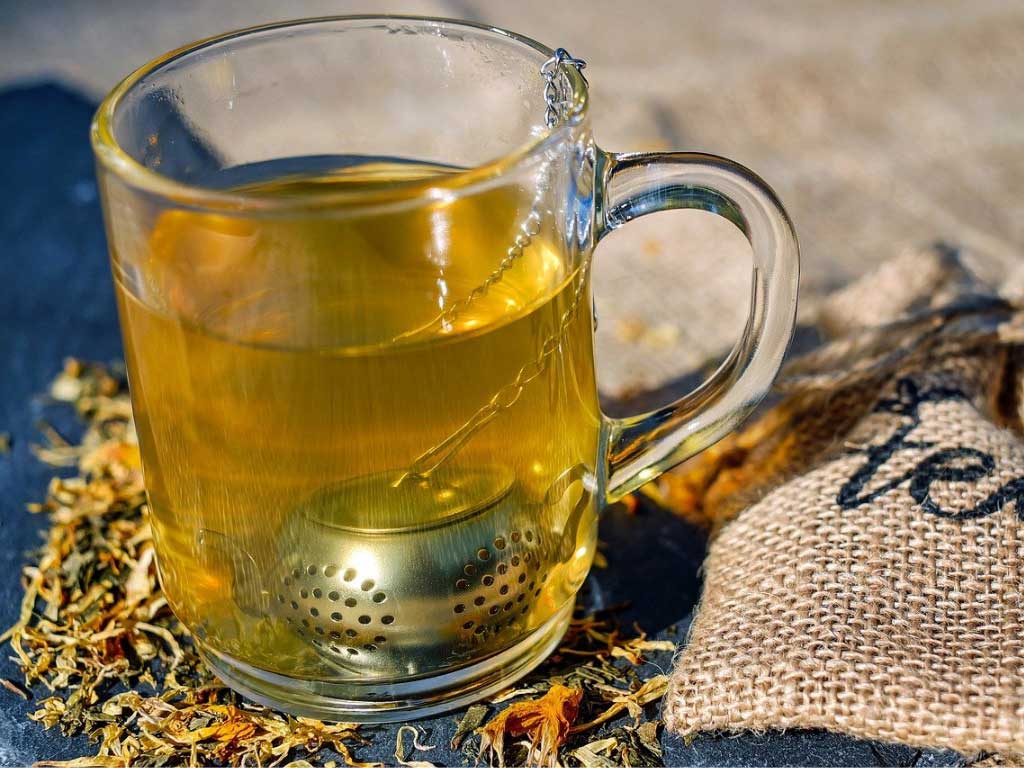 Eine Tasse grünen Tee aus Vietnam gemischt mit Safran, Safranfäden und Kardamom aus Indien und Afghanistan. Tee wird serviert zu Snacks, Nüssen, Trockenfrüchten oder anderen Lebensmittel und ist fester Bestandteil der afghanischen und persischen Kultur.